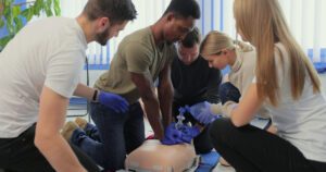 Closeup of students practicing CPR chest compression on dummy. cpr-training-seattle-6-300x158